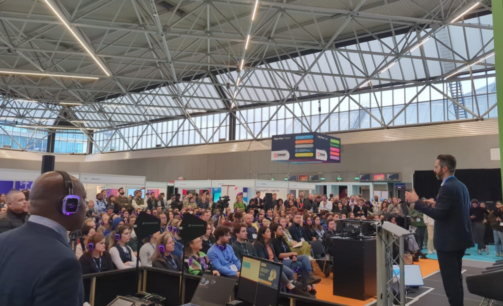 Keynote speaker presenting at the DMWF Global 2024 exhibit hall